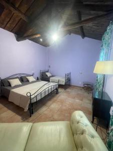 a bedroom with two beds and a couch in a room at Azienda Agricola Neocastrum in Lamezia Terme
