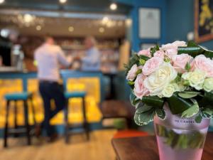 a vase filled with pink and white roses on a table at Ashton Court Hotel in Exmouth