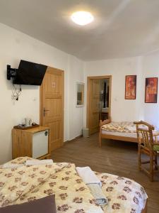 a room with two beds and a tv on the wall at House Maka in Rudanovac