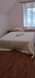 a bedroom with a bed with white sheets and a window at ST MALON SUR MEL in Saint-Malon-sur-Mel +3 photos