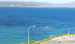 a street light next to a large body of water at Ático Alefriz in Fisterra