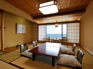 a dining room with a table and chairs at Inatori Ginsuiso in Higashiizu