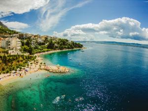 an aerial view of a beach with people in the water at Apartmani Miljak Omiš in Omiš