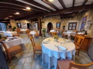 a dining room with white tables and chairs in a restaurant at El pucheru 4 Almas in Barcenaciones