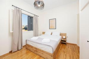 a white bedroom with a bed and a window at S37 Acropolis View in Athens