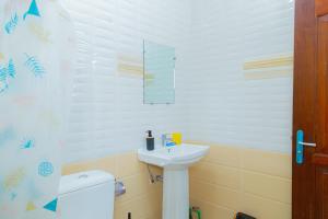 a white bathroom with a sink and a toilet at Studio Elma in Abidjan +5 photos