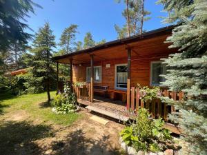 ポッドンビエにあるLeśne Zaciszeのポーチとデッキ付きのログキャビン