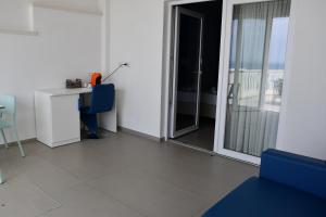 a room with a table and a desk and a window at Terrazze Naos in San Leone