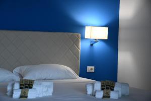 a bedroom with a white bed with a blue wall at Terrazze Naos in San Leone