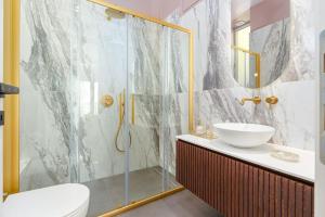 Un baño con ducha de cristal y lavabo. en Luxury Apt with Acropolis view Balcony and Jacuzzi, en Atenas 34 fotos más