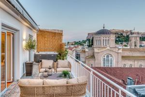Un balcón con sofás y vista a una ciudad. en Luxury Apt with Acropolis view Balcony and Jacuzzi, en Atenas