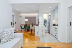 Una sala de estar con un sofá blanco y una cocina. en Luxury Apt with Acropolis view Balcony and Jacuzzi, en Atenas