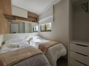 a group of three beds in a room at Ap Moderno Ap 21 Soho Life in Curitiba