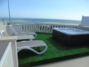 a hot tub on a balcony with the ocean at Terrazze Naos in San Leone