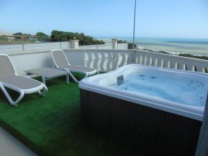 a hot tub on top of a balcony with chairs at Terrazze Naos in San Leone