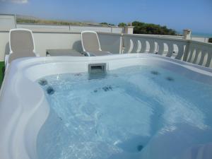a jacuzzi tub sitting on top of a balcony at Terrazze Naos in San Leone