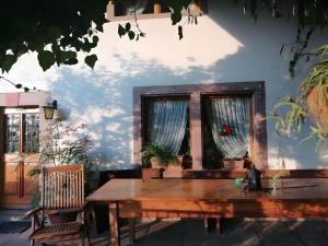 a wooden table in front of two windows at Small holiday cottage Ivy in Schuttertal