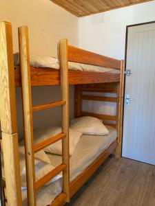 two bunk beds in a room with a door at Studio cabine vue mer saint pierre la mer in Fleury