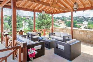 a patio with couches and tables and a wooden roof at Villa Elizabeth in Limassol