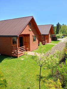 quelques cabanes en bois dans une cour dans l'établissement Domki U Julka Nad Jeziorem Solińskim z Jacuzzi, à Werlas