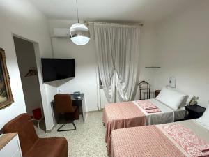 a hotel room with two beds and a television at Casa Giulia in Porto SantʼElpidio