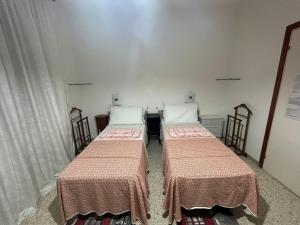 two beds sitting in a room with curtains at Casa Giulia in Porto SantʼElpidio