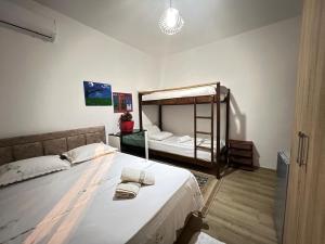 a bedroom with a bed and a bunk bed with two towels at David Guesthouse in Shkodër