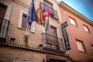 two flags hanging on the side of a building at Hostal Tic-Tac in Mocejón
