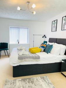 a bedroom with a large white bed with colorful pillows at Mount Yard - Stylish Cottage - Close to Alton Towers - Peak District - Stoke-on-Trent Sleeps 5 in Totmonslow