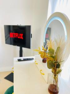 a desk with a mirror and a vase with plants at Mount Yard - Stylish Cottage - Close to Alton Towers - Peak District - Stoke-on-Trent Sleeps 5 in Totmonslow