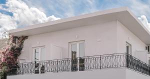 a white house with a balcony at Sea Sailing Apartments in Kontokali