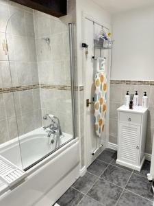 a bathroom with a shower and a tub and a sink at Mount Yard - Stylish Cottage - Close to Alton Towers - Peak District - Stoke-on-Trent Sleeps 5 in Totmonslow