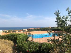 a swimming pool with the ocean in the background at Studio cabine vue mer saint pierre la mer in Fleury