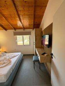 a bedroom with a bed and a desk with a computer at Adem Hillcrest Apartments in Sarandë