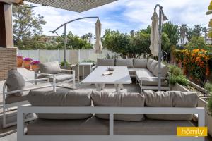 eine Terrasse mit Sofas, einem Tisch und Stühlen in der Unterkunft Villa con piscina privada - Villa Golf 2 in Motril