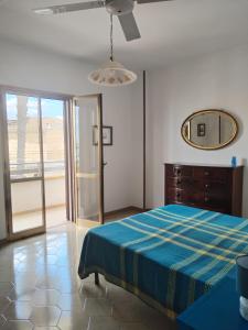 um quarto com uma cama e um espelho na parede em Sunset Villa em Torre Lapillo