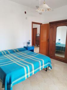 um quarto com uma cama azul e um espelho em Sunset Villa em Torre Lapillo