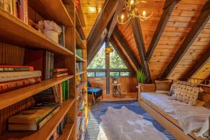 Una sala de estar en una cabaña de troncos con un sofá y libros. en Hygge Haus Sequoia - Large Private Cabin w Views, en Ponderosa