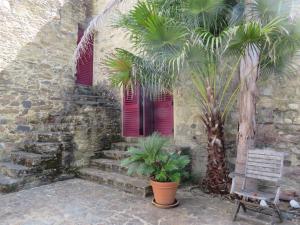 un edificio in pietra con palme davanti a una finestra di Casa do Chão Redondo a Montes da Senhora