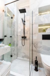 un bagno bianco con doccia e lavandino di Sofia Royal Retreat a Sofia Altre 32 foto