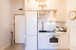 una cucina con elettrodomestici bianchi e un orologio sul muro di Sofia Royal Retreat a Sofia