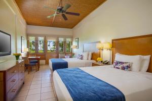a hotel room with two beds and a flat screen tv at Copamarina Beach Resort & Spa in Guanica