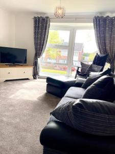 a living room with a couch and a tv at Morpeth Apartment in Morpeth