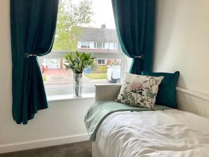 a bed in a room with a window with a vase at Morpeth Apartment in Morpeth