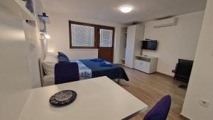 a room with a bed and a table and a tv at Plitvice ZG in Smoljanac