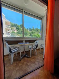 a room with a table and chairs and a large window at Apartmani Miljak Omiš in Omiš +53 photos
