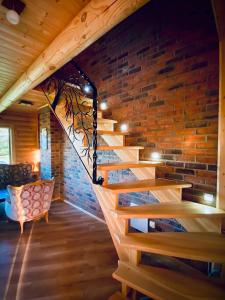a staircase in a room with a brick wall at Cozy Cabins Vydmantai in Kiauleikiai