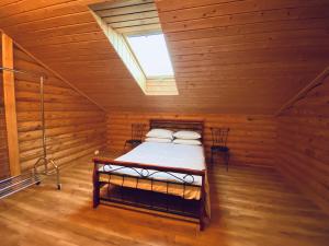 a bedroom with a bed in a log cabin at Cozy Cabins Vydmantai in Kiauleikiai