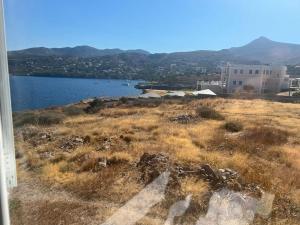 a view of a field with a body of water at Perdika's Cove, spacious sea view family home in Perdhika +12 photos