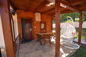 eine Veranda mit einem Tisch und einer Schaukel in der Unterkunft Mijatov Konak in Zlatibor